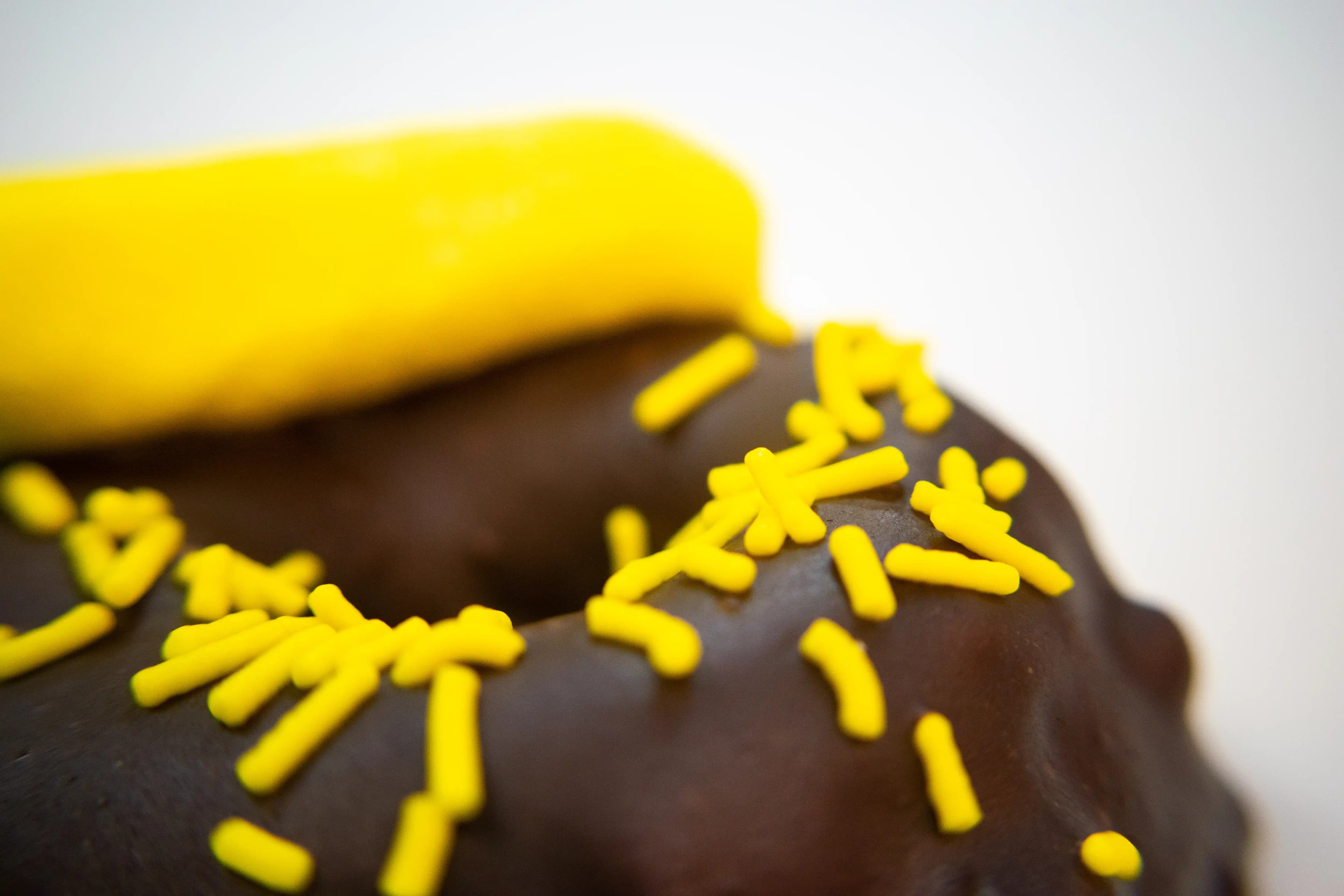 A close-up detail shot of Rotten Apples Canna Co.'s Chocolate Covered Banana Nut Donut.