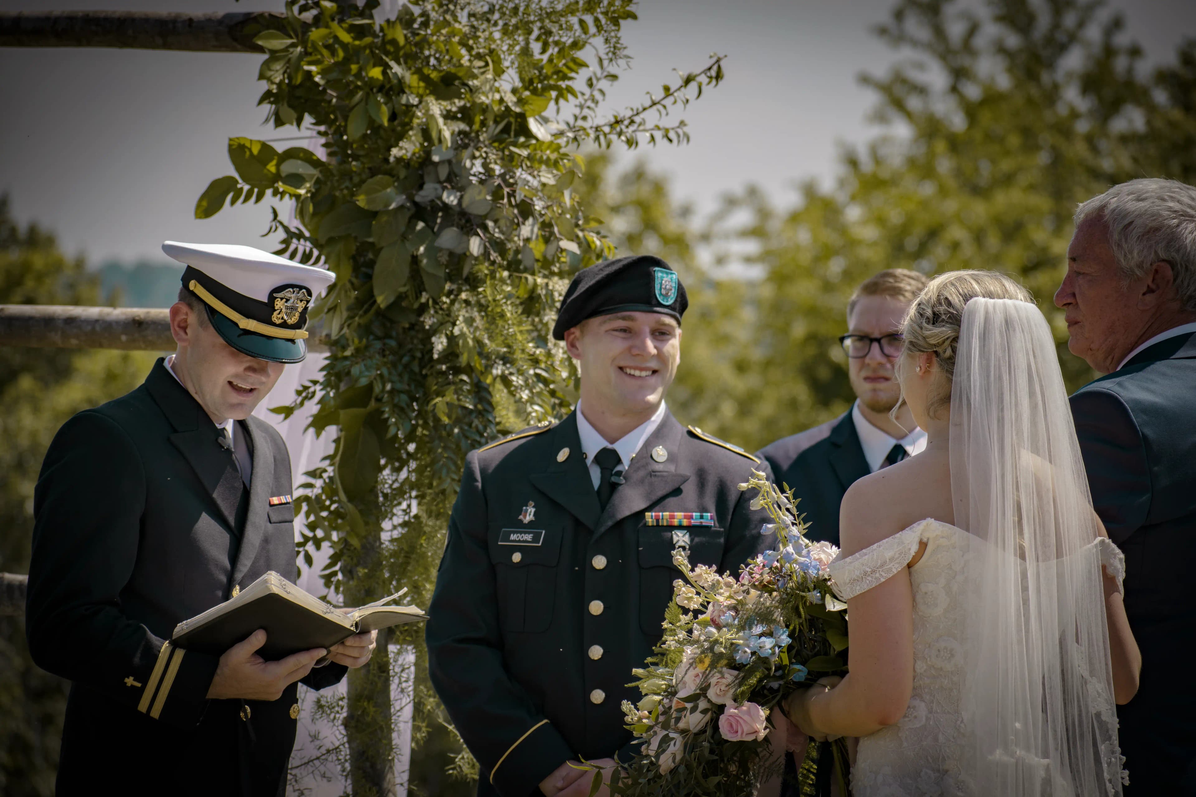 the groom smiles as the bride walks down the aisle of the wedding ceremony.