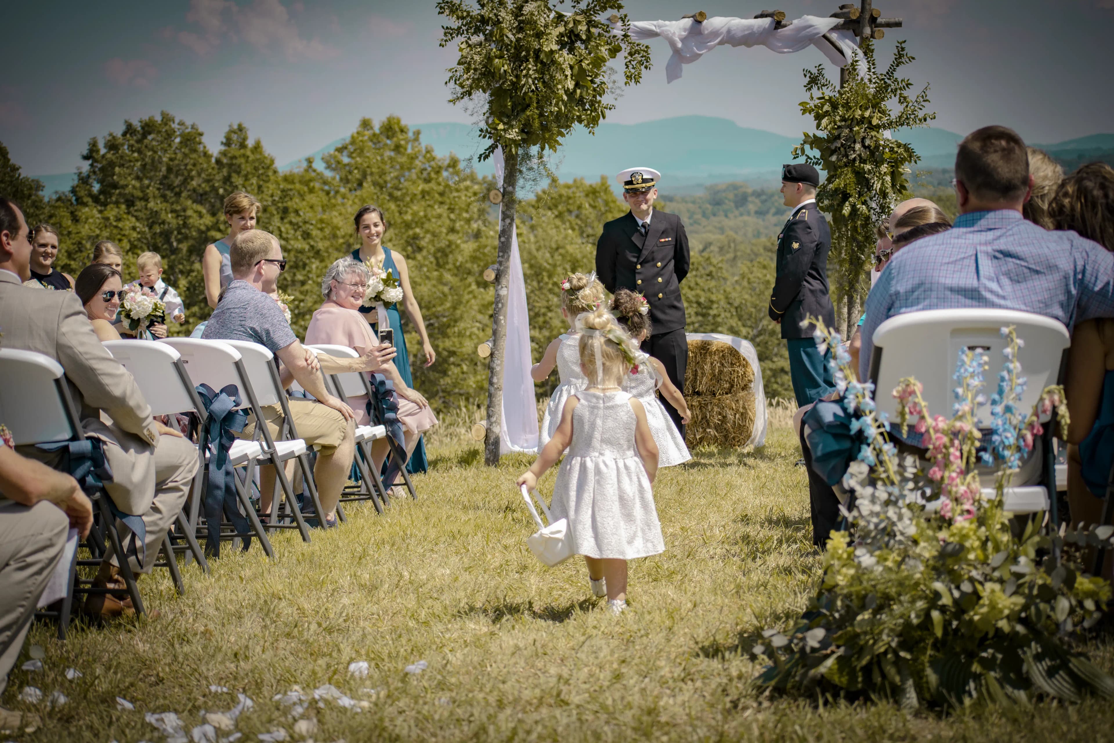 Flower girls walking down the aisle during C + L wedding ceremony.