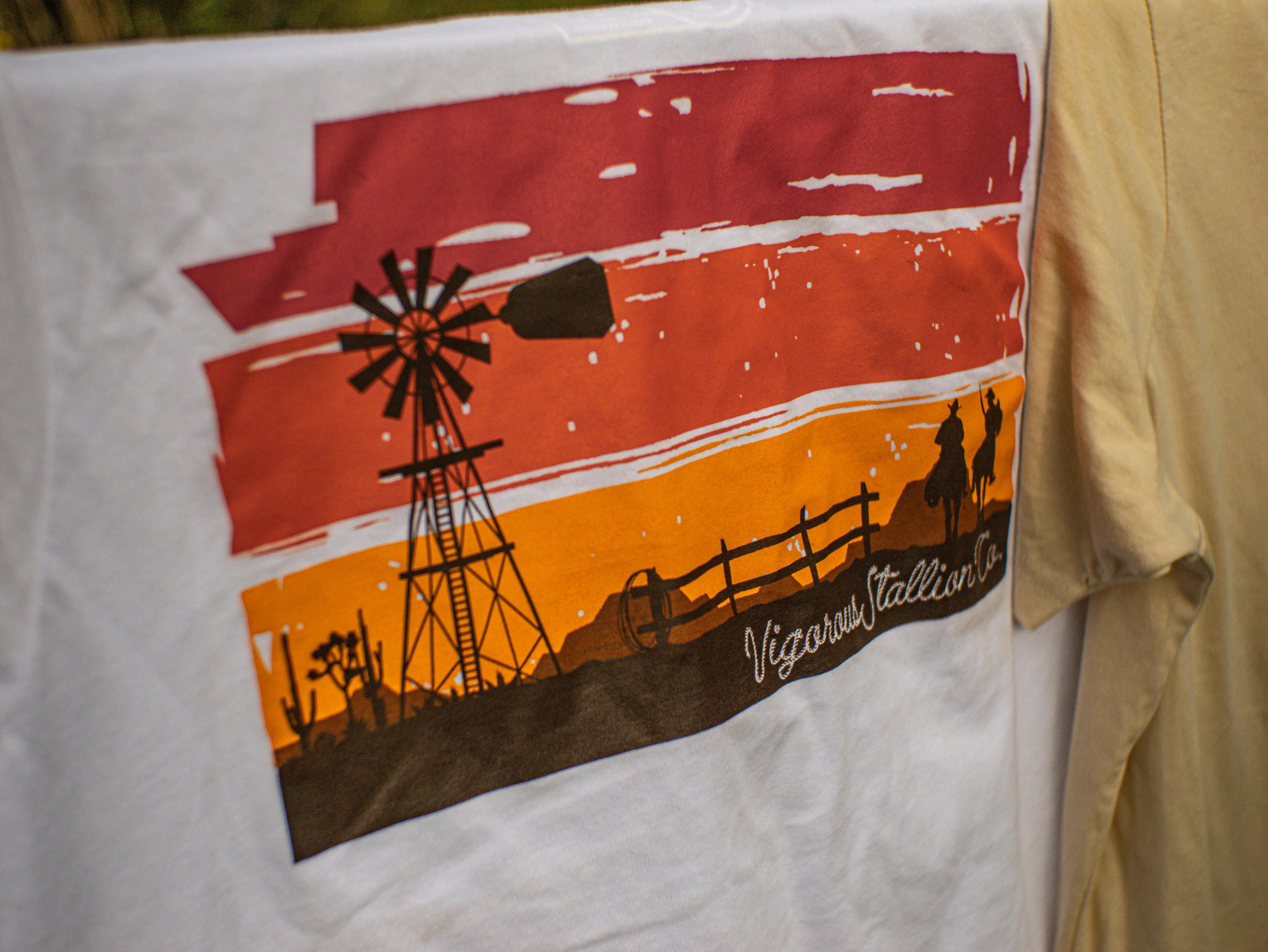 Close-up photograph of the Sunset Bandit Shirt draped over a wood fence.