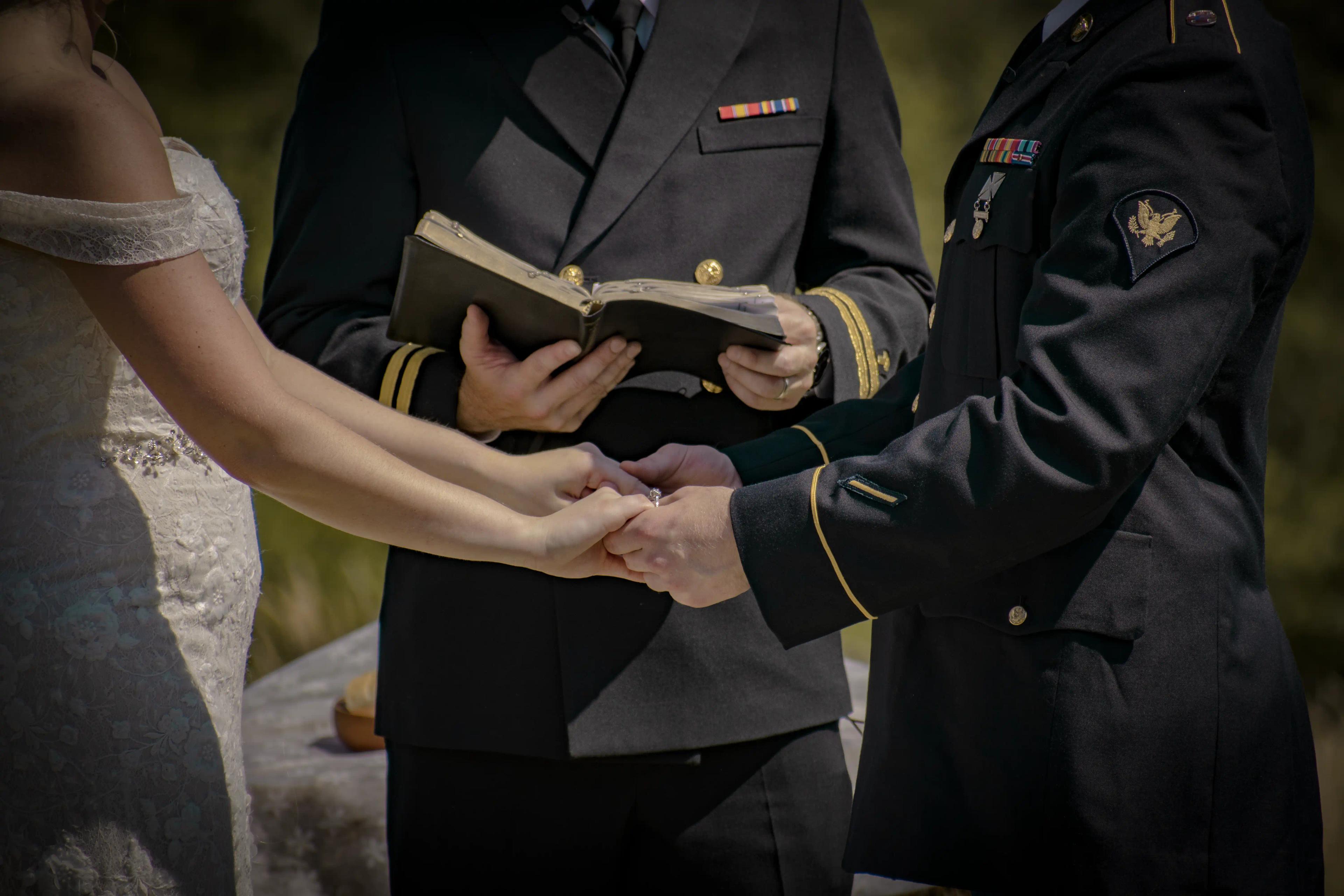 a close-up view of C + L holding hands while the officiant reads their vows. 