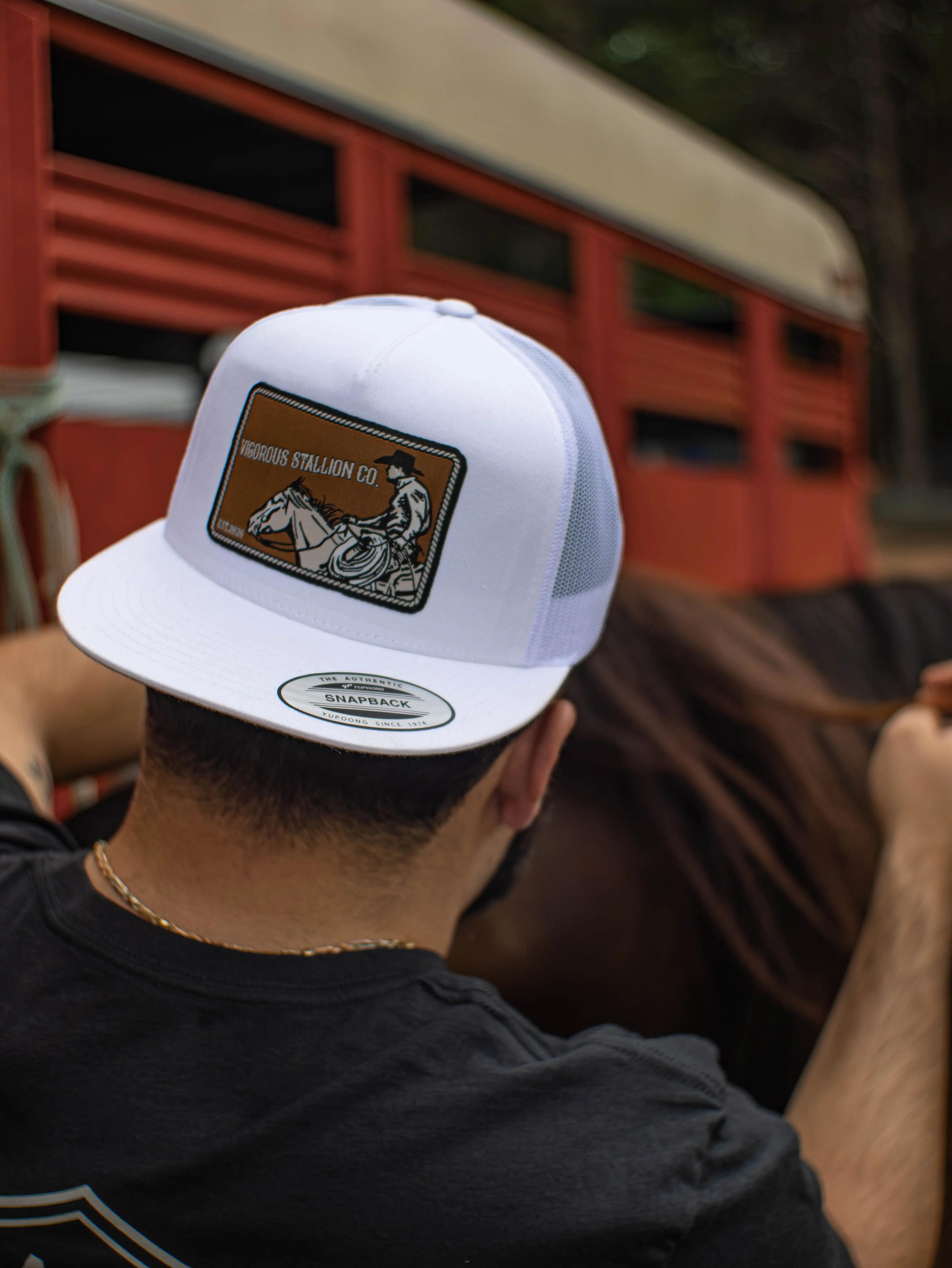 Close-up photograph of the Roper snapback hat on a man grooming a horse.