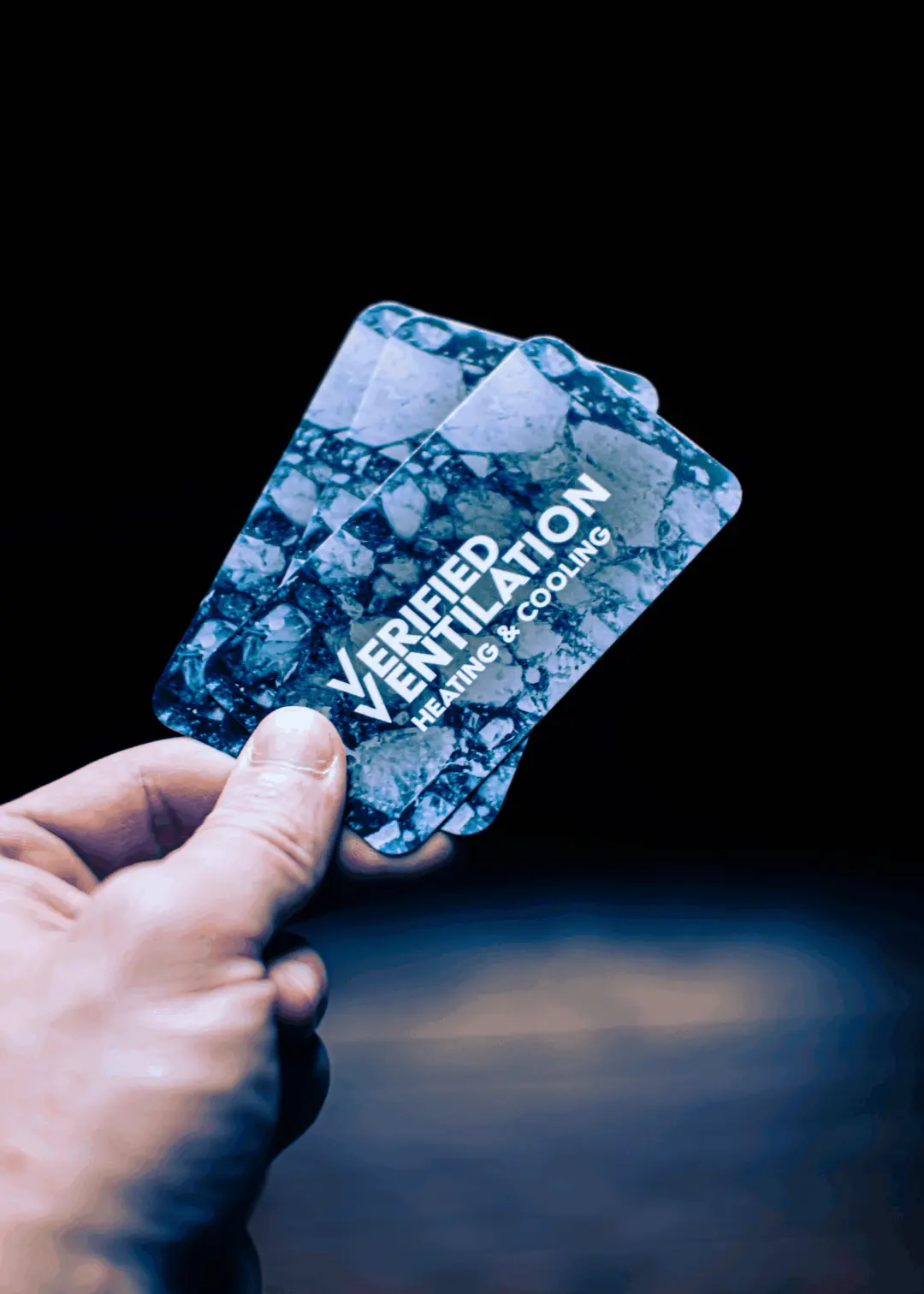 An animated image showing the front side of Verified Ventilations business cards being twisted to show the glossy coating of the cards.